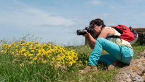 a female photographer taking a photograph, outdoors